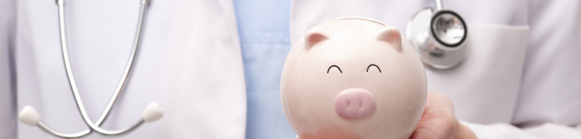Doctor holding piggy bank